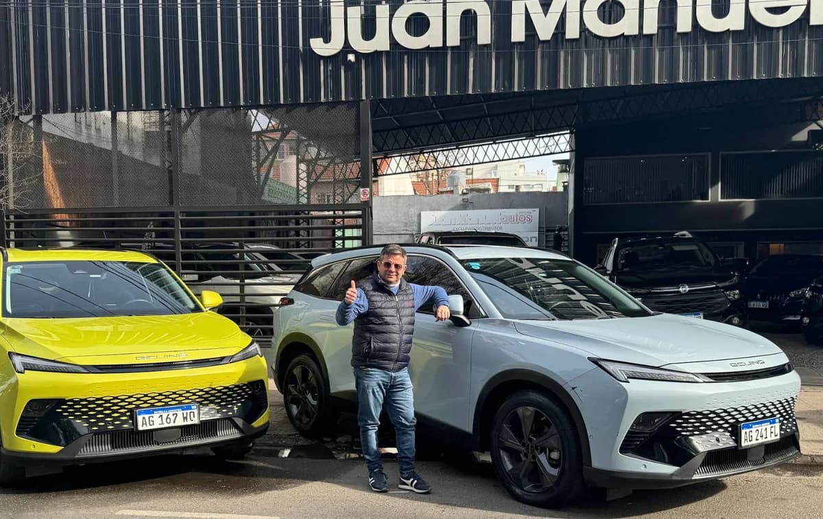 Juan Manuel entre dos vehículos, al frente de Juan Manuel Autos