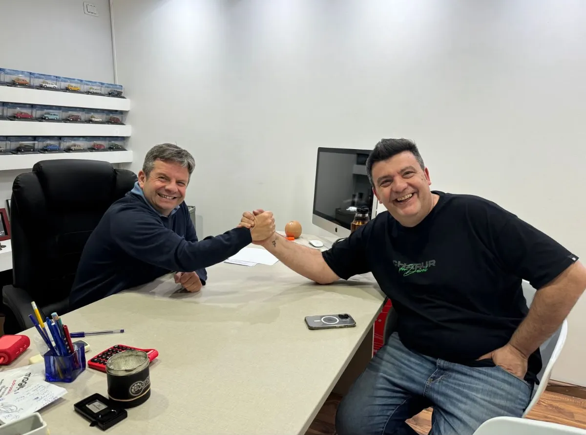 Juan Manuel y un cliente sonrientes, dándose la mano en la oficina