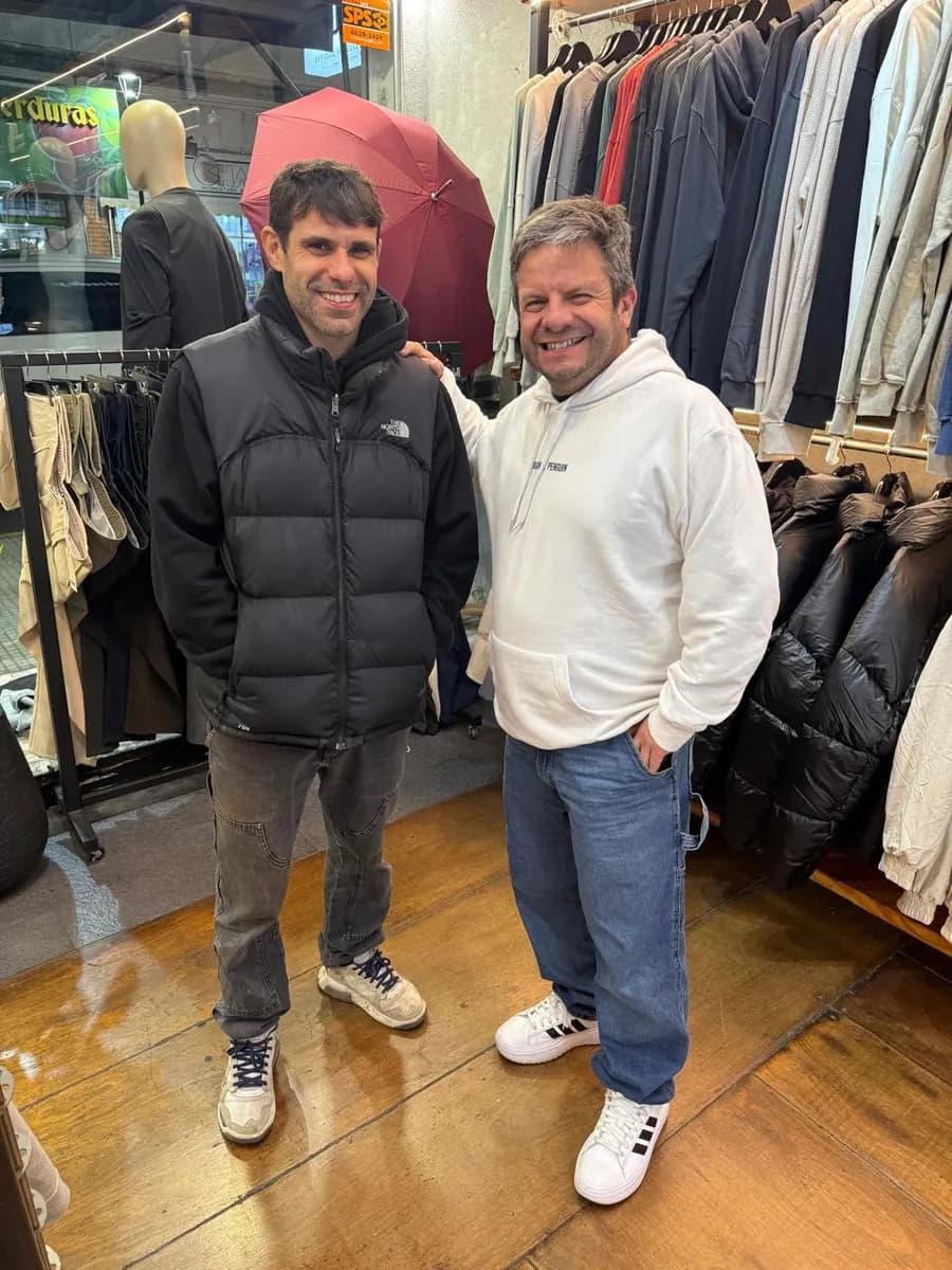 Juan Manuel posa con un cliente en un local de ropa