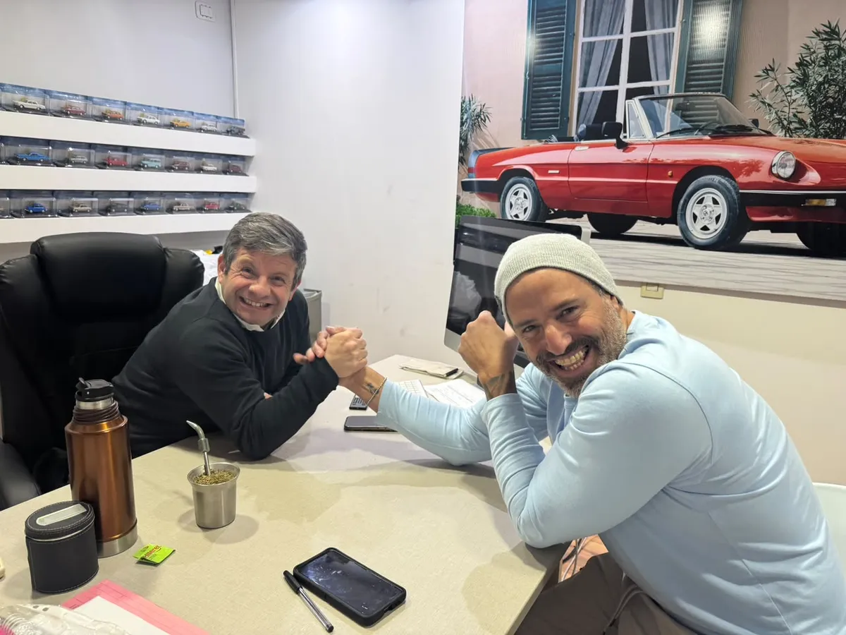 Juan Manuel y un cliente se dan la mano riéndose en la oficina