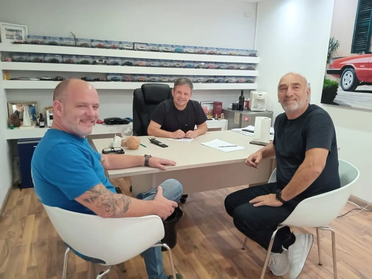Juan Manuel con dos clientes sentados en la oficina del local