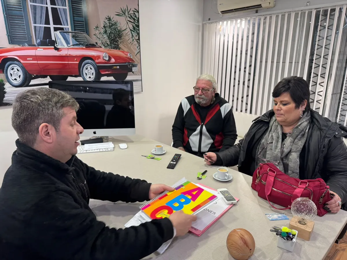Juan Manuel atiende a una pareja de clientes en el escritorio de la oficina